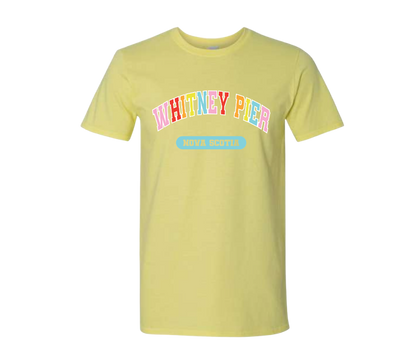 A pale yellow short-sleeve t-shirt with 'WHITNEY PIER' printed in colourful bubble letters and a light blue 'NOVA SCOTIA' graphic on the front, displayed against a solid white background.